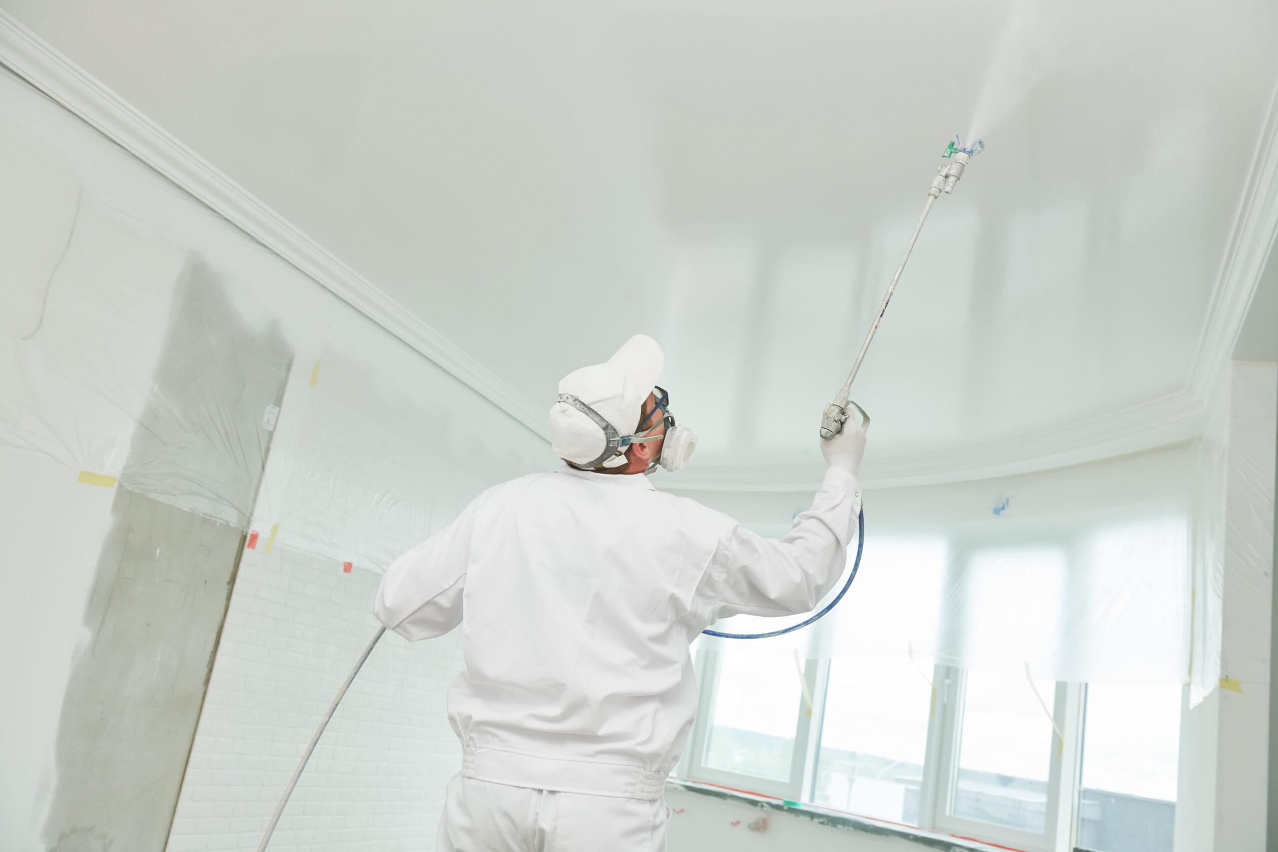 Professional painter spraying ceiling using painting estimating software workflow