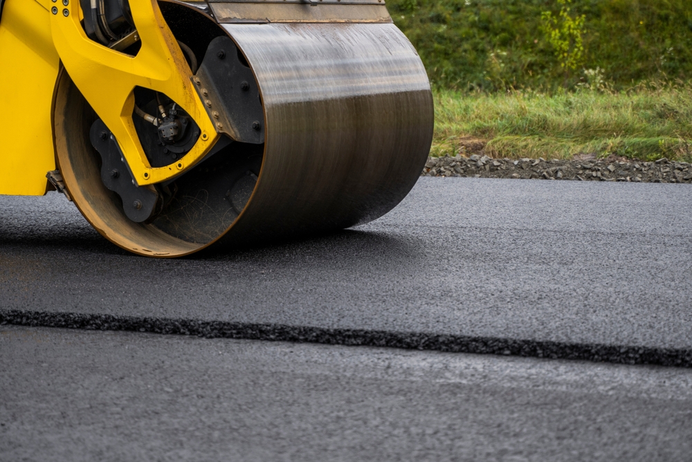 Road roller paving a municipal roadway for public works infrastructure