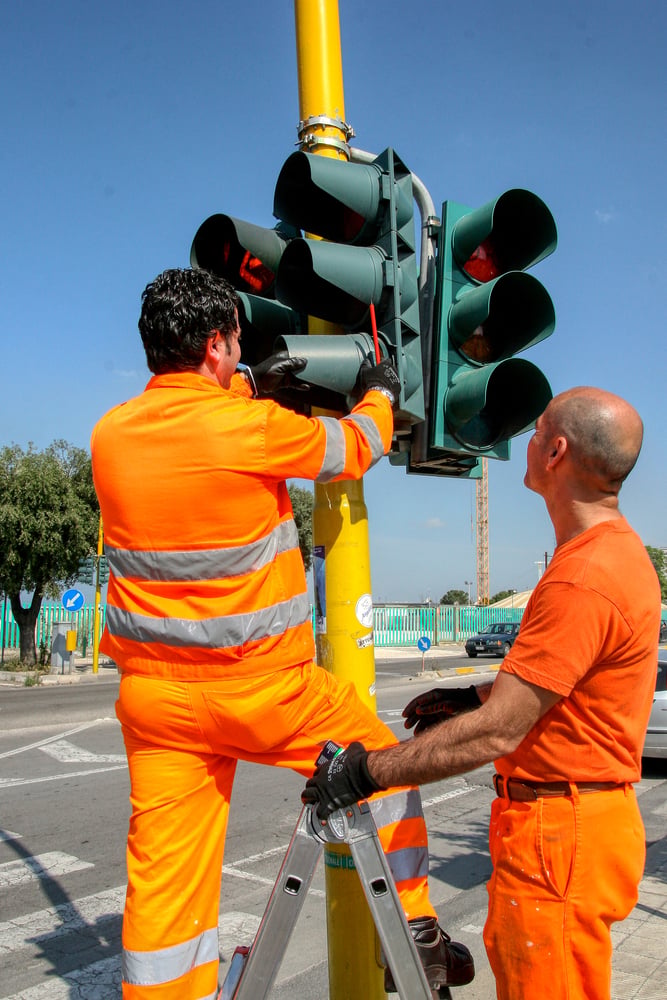 Municipal workers servicing traffic signal infrastructure representing internal labor and capital project support